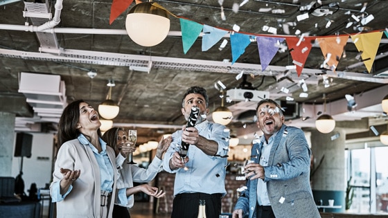 Image of three colleagues at an office celebration