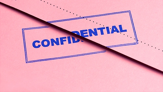 Image of a pink document with confidential written on it in blue lettering