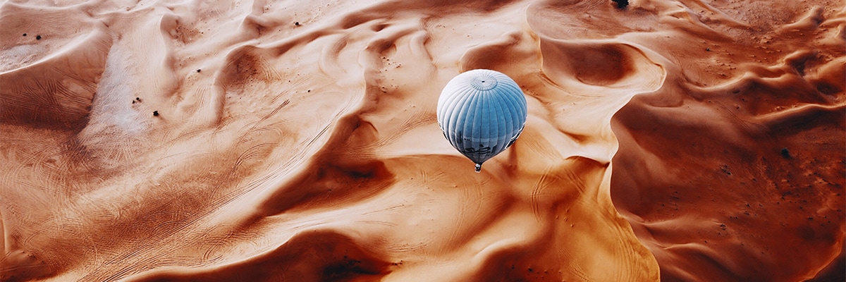 Hot air balloon flying over a desert landscape