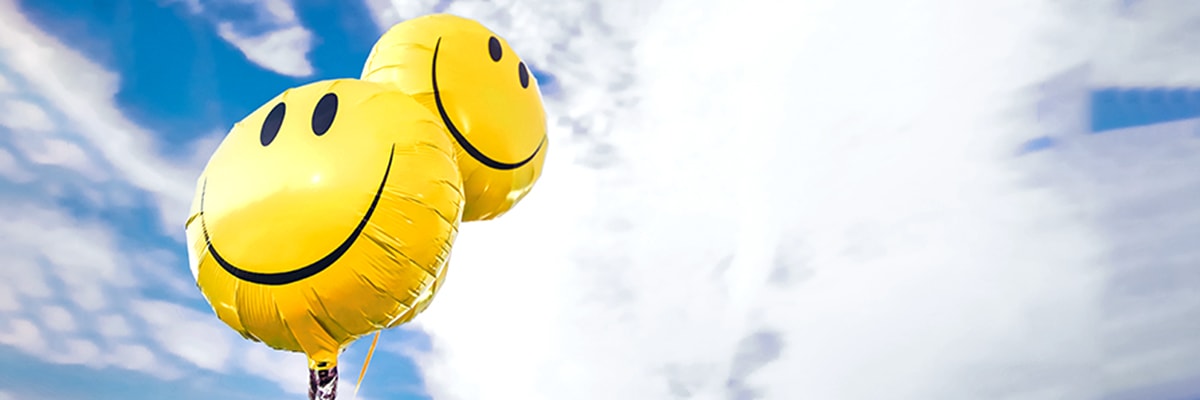 Image of two yellow balloons with smiley faces