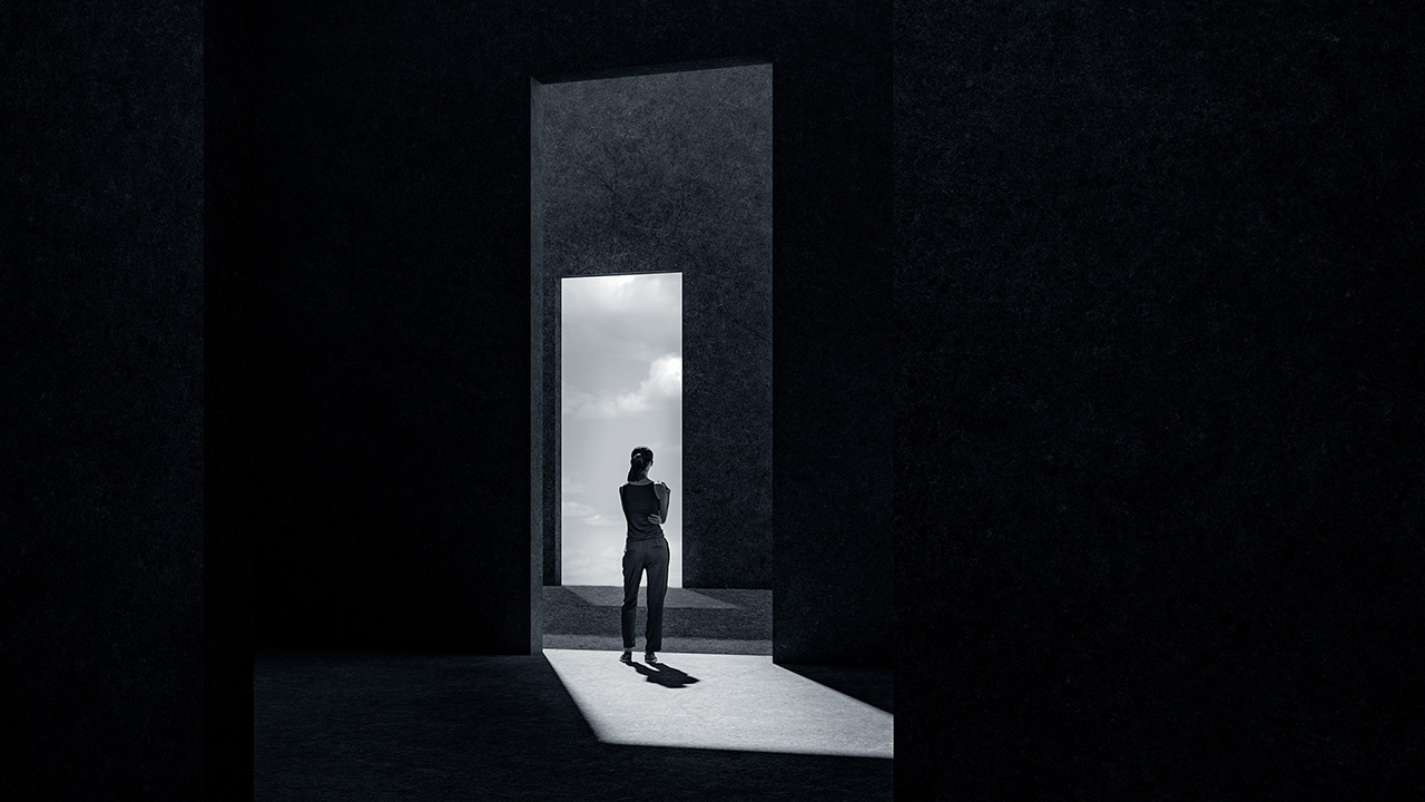 Image of a woman seen through a doorway in black and white
