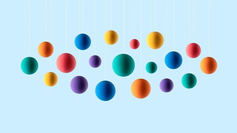 Image of rainbow colored spheres hanging on strings