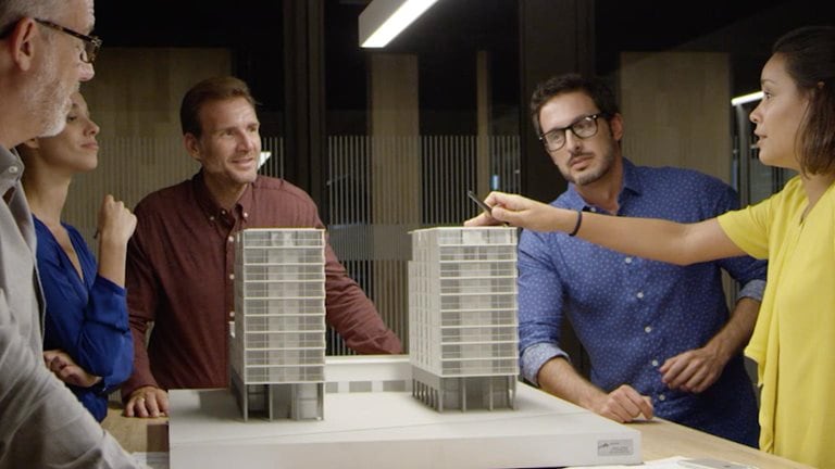 Architects examining a model high-rise building