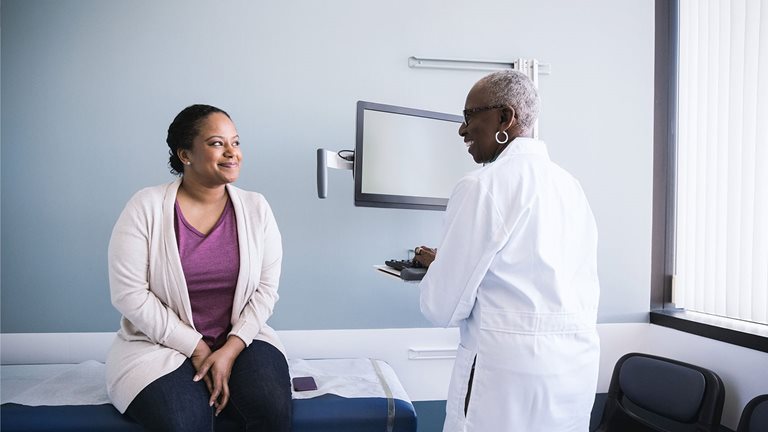 Photo of a Black female doctor advising her patient