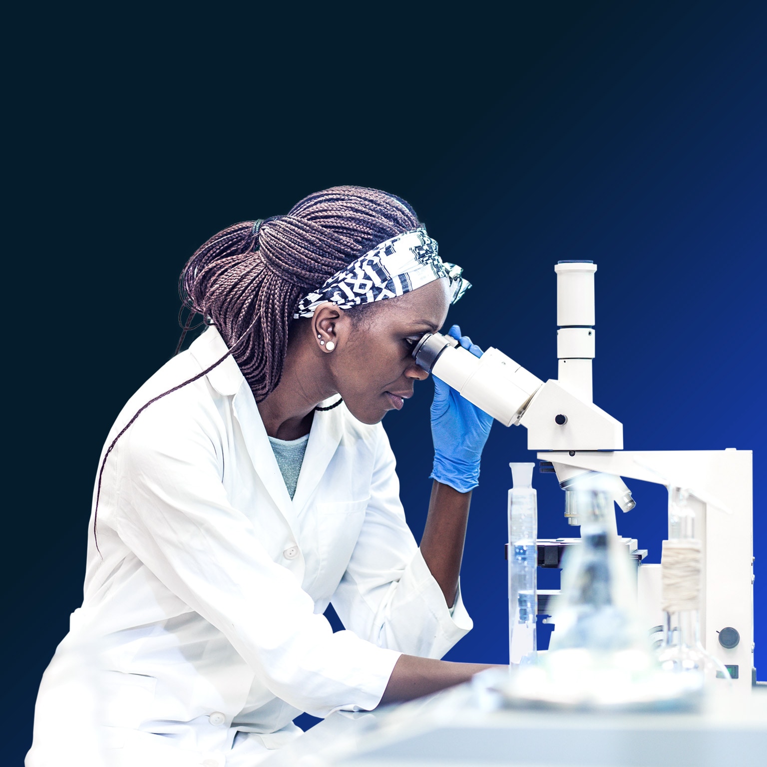 Image of a Black female scientist working in the laboratory, using a microscope