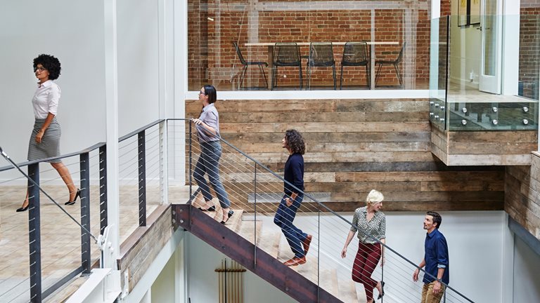 Office workers walking up a staircase in a line