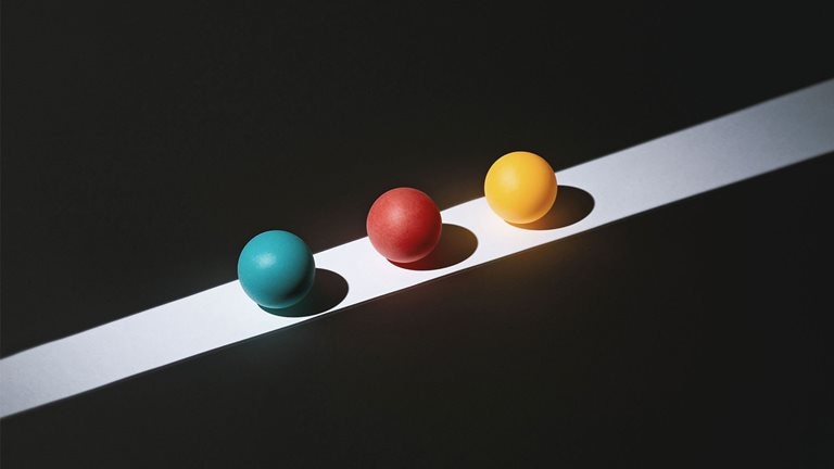 Three colored spherical objects on a black and gray background
