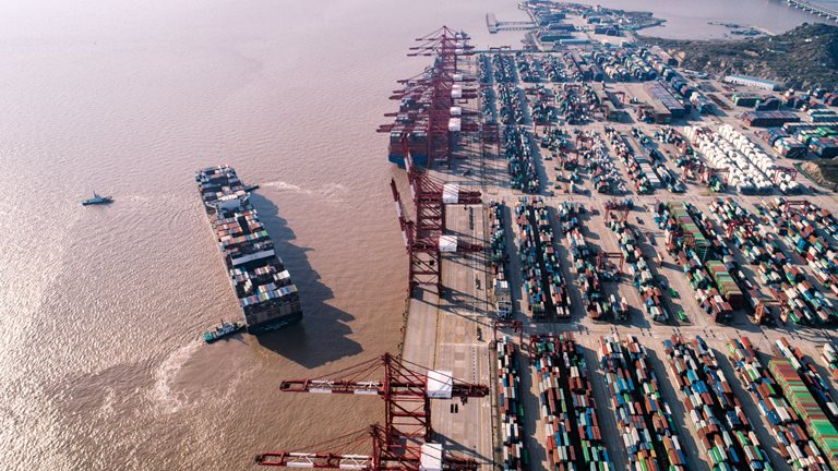 Image of a large container ship moored off a port facility