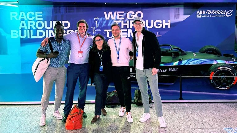 McKinsey colleagues standing in front of an electric race car