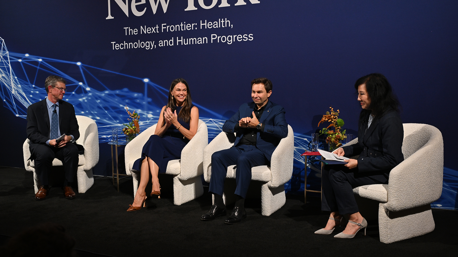 Four panelists sit on stage at McKinsey & Company's The Future of New York event, with two panelists applauding.