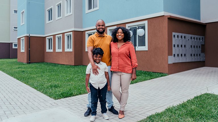 Portrait of a happy family in front of their new apartment