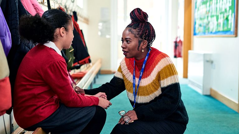 A primary school teacher offering support to a student