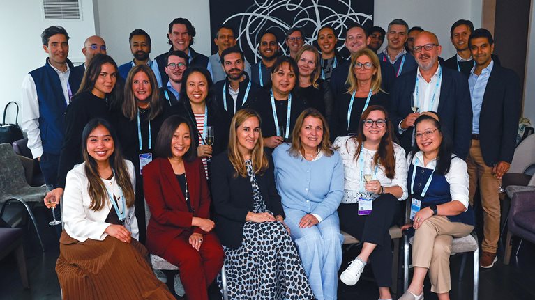 Group of Dreamforce attendees posing together for a photo at an indoor event.