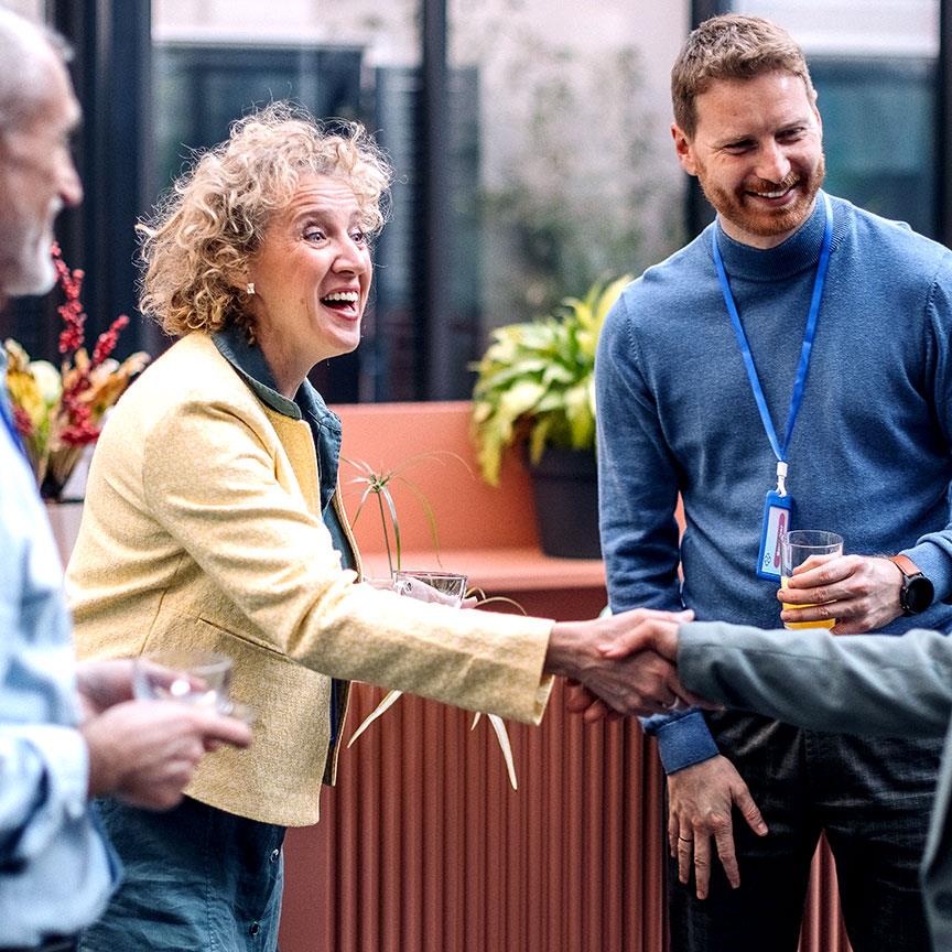 Business people on a break while attending business conference, greeting and shaking hands