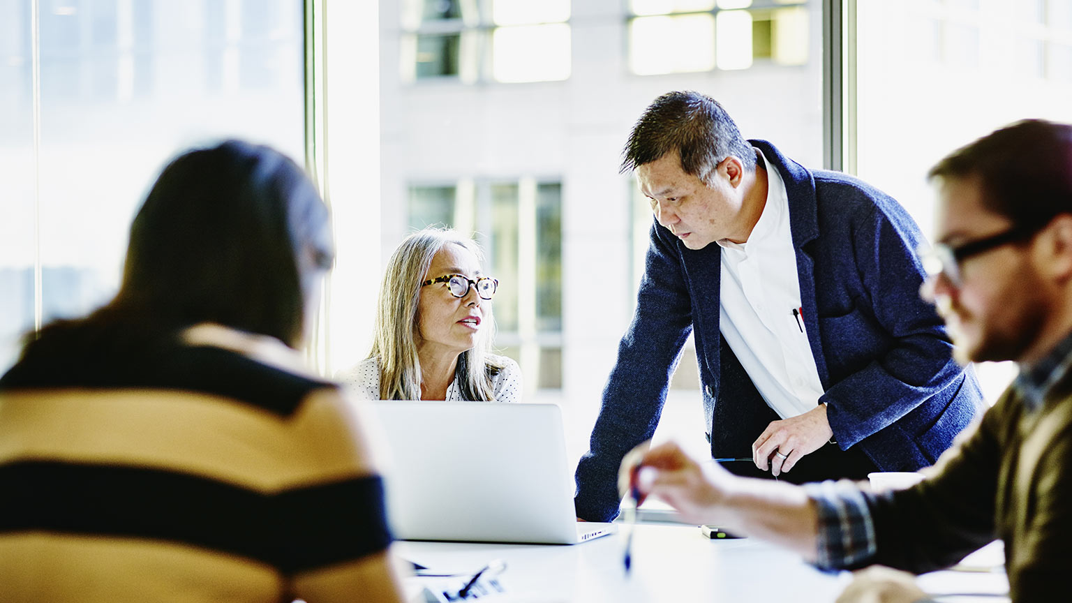 Four colleagues working together in a conference room