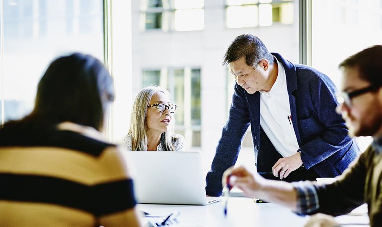Four colleagues working together in a conference room