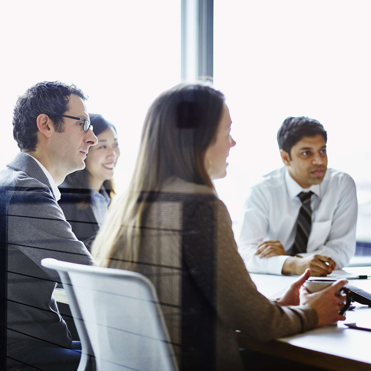 Business meeting with four people gathered around conference table