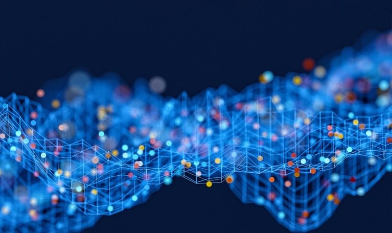 An abstract rendering of a data wave, with interconnected blue lines forming a grid-like structure. Spheres in shades of red, yellow, and blue, representing data points within raw data sets, are distributed across this grid, set against a solid dark blue background.