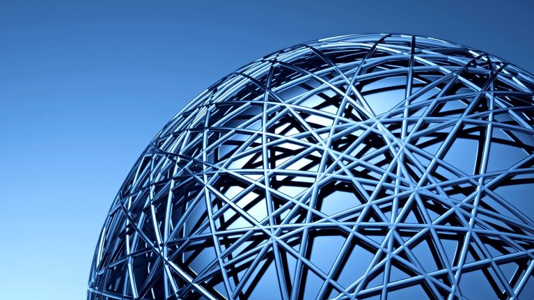 A close-up view of a large metallic spherical structure made of interwoven beams, creating a complex geometric pattern.