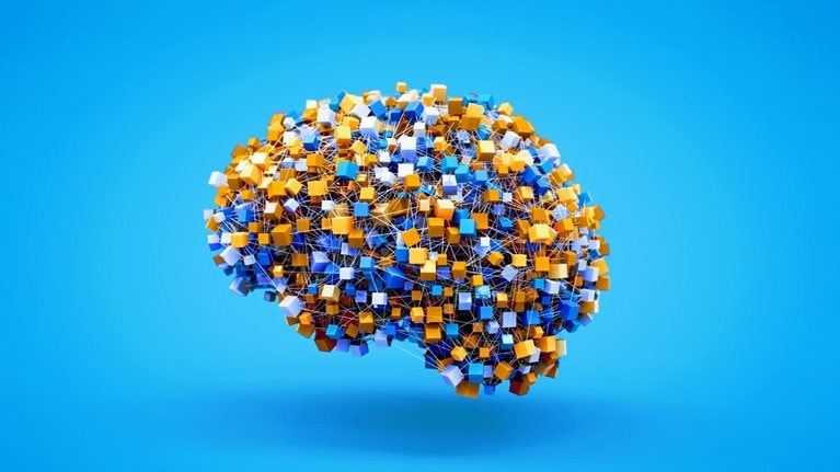 A stylized, three-dimensional rendering of a human brain. The brain is constructed from numerous small, colorful cubes—primarily blue, white, and gold—connected by thin, white lines on a light blue background.