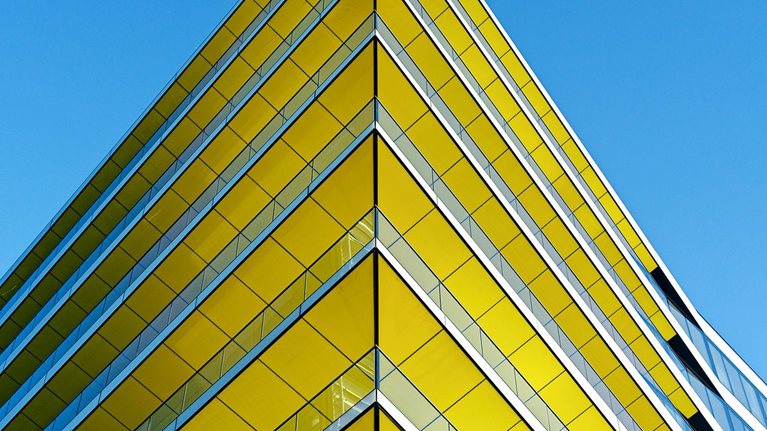 Low angle view of contemporary office building in Central London. Yellow ceilings, blue sky