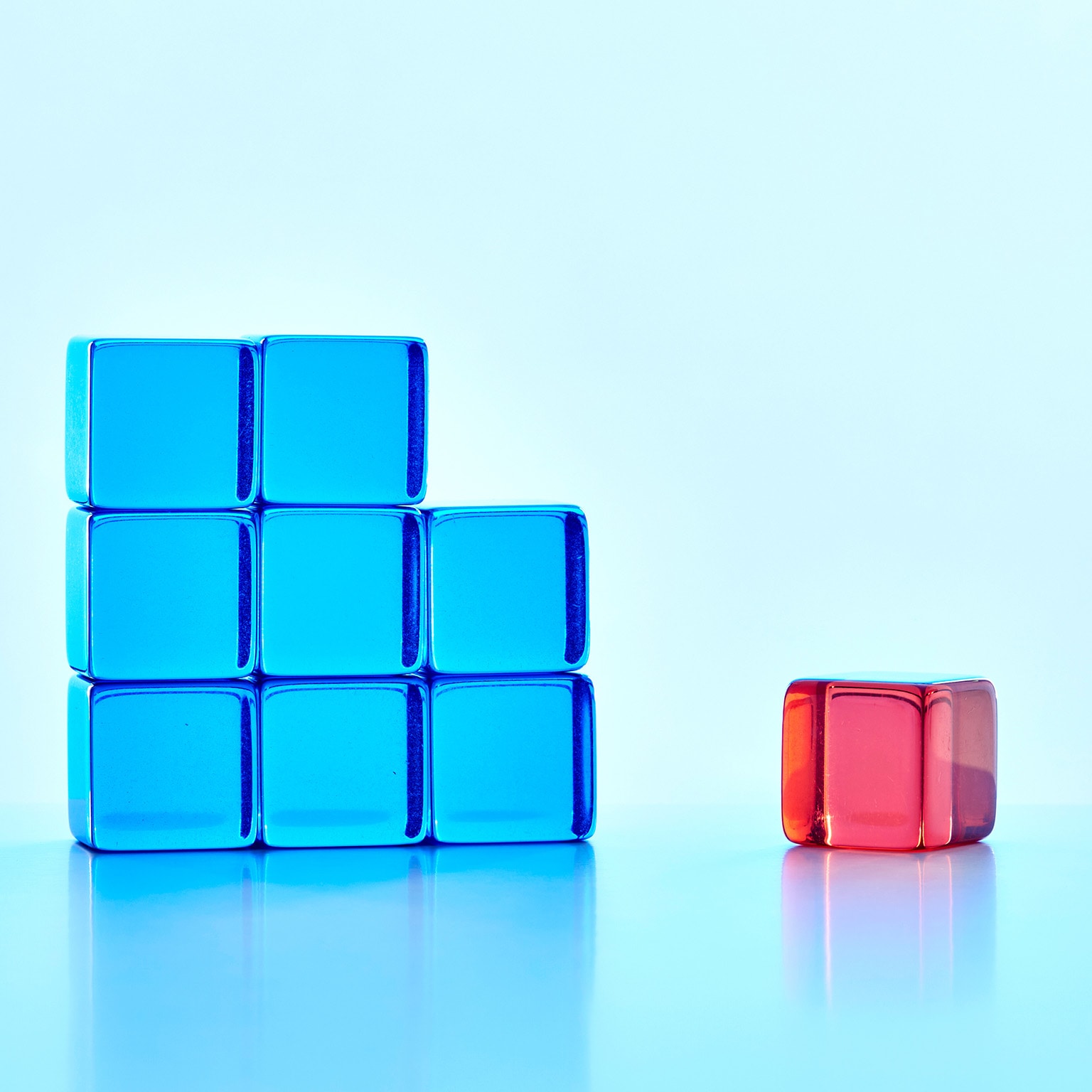 An incomplete blue square shape with one red cube standing apart