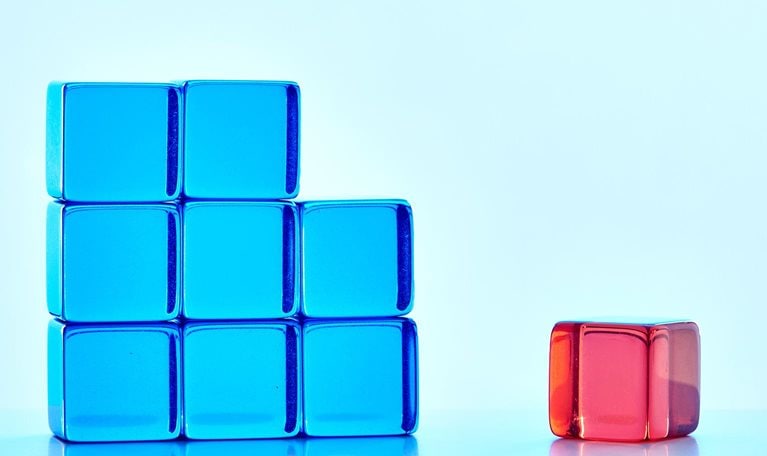 An incomplete blue square shape with one red cube standing apart