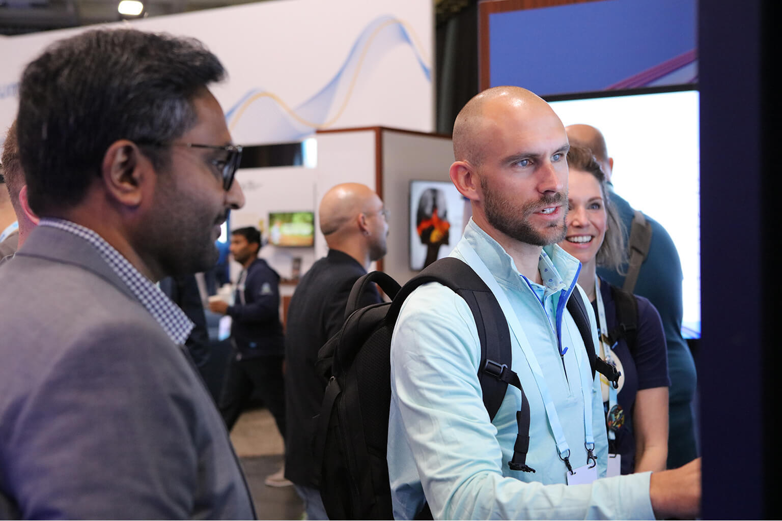 Professional conference attendees at booth.