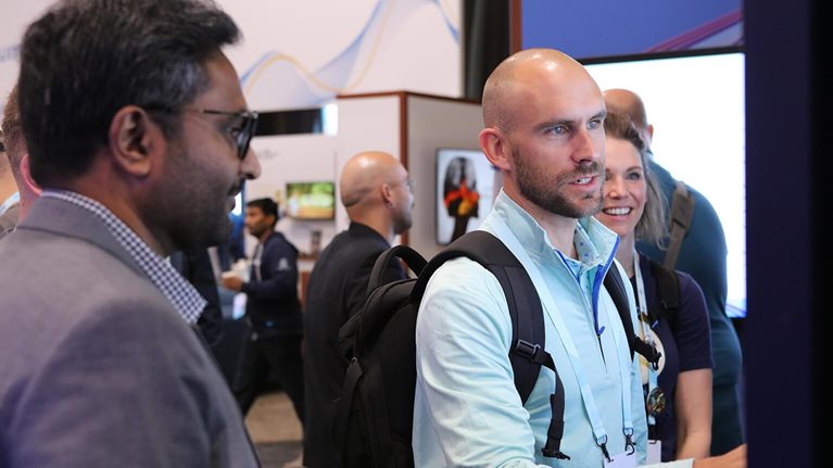 Professional conference attendees at booth.