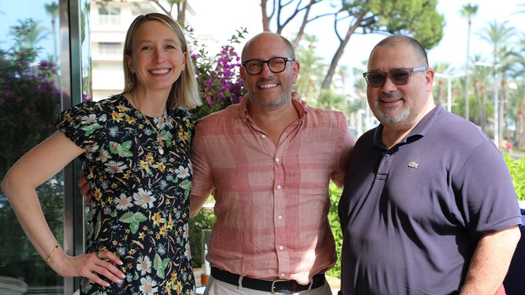 A trio of Cannes Lions 2025 attendees smiling together