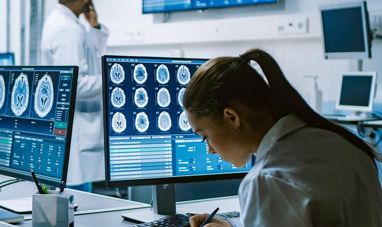 Team of Professional Scientists Work in the Brain Research Laboratory. Neurologists / Neuroscientists Surrounded by Monitors Showing CT, MRI Scans Having Discussions and Working on Personal Computers. - stock photo