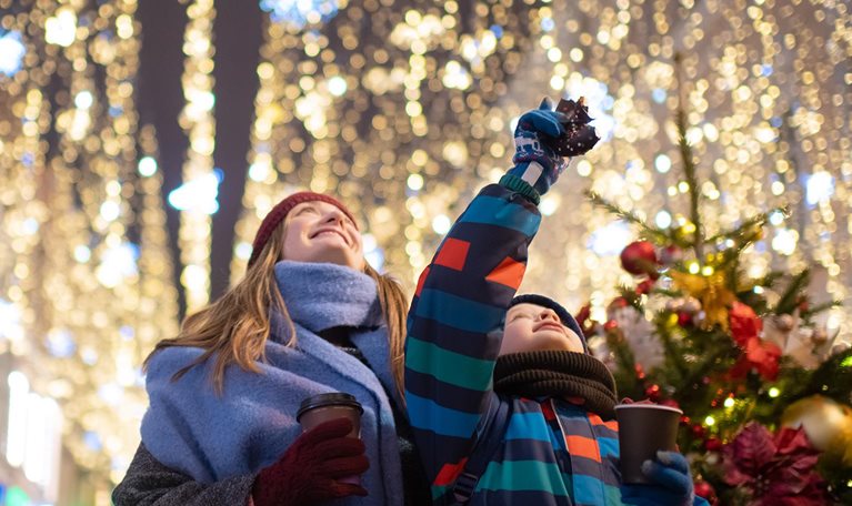 Little boy with his mother buying tera and sweets at a Christmas market.