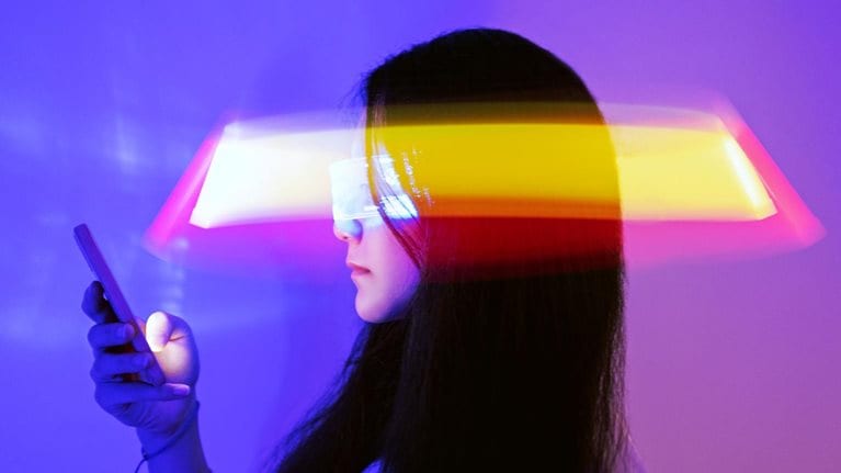 Asian woman using smartphone surrounded by beams of light