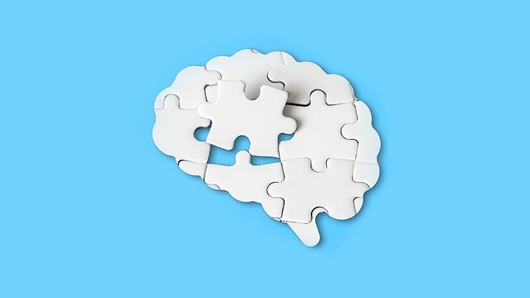 Missing piece in the brain shaped jigsaw puzzle fits into place. - stock photo