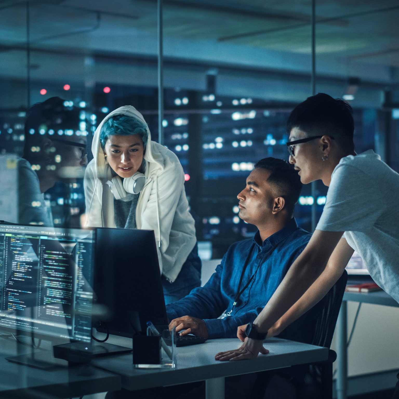 Diverse team of professionals meeting in office at night