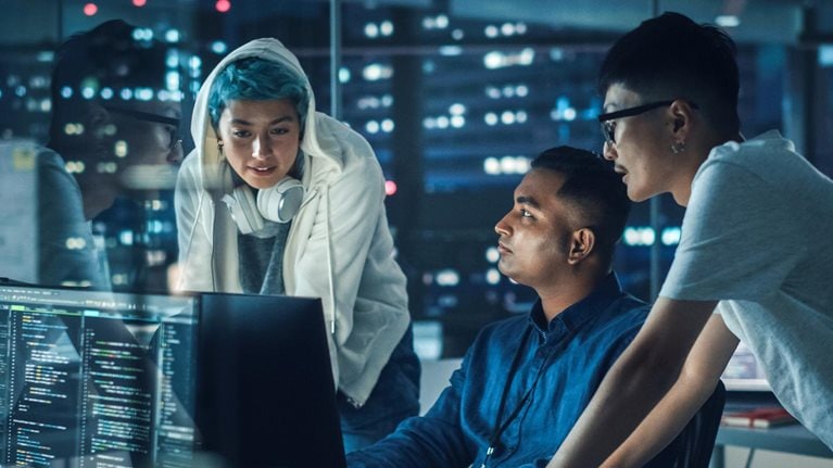 Diverse team of professionals meeting in office at night