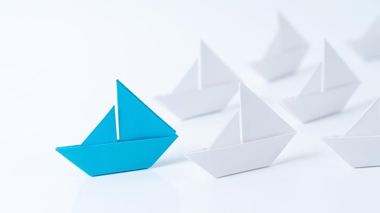Leadership conceptual using blue paper ship - stock photo