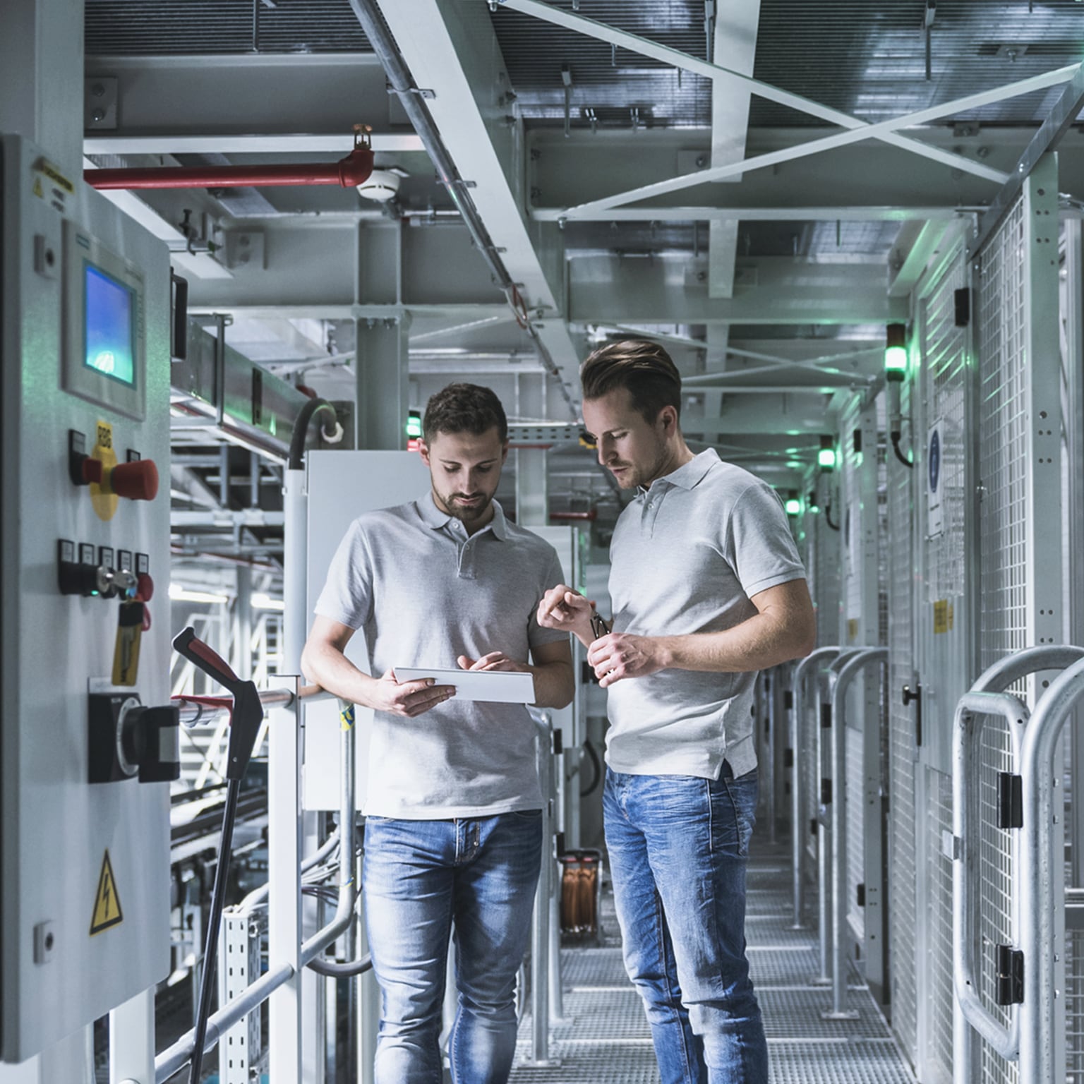 Two men in automatized high rack warehouse looking at tablet