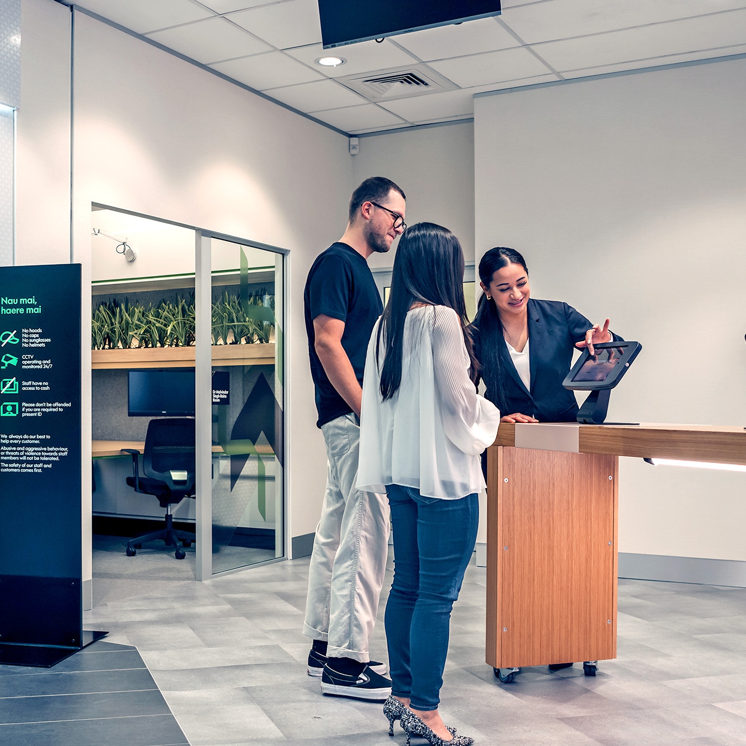 Kiwibank staff helping customers using a tablet