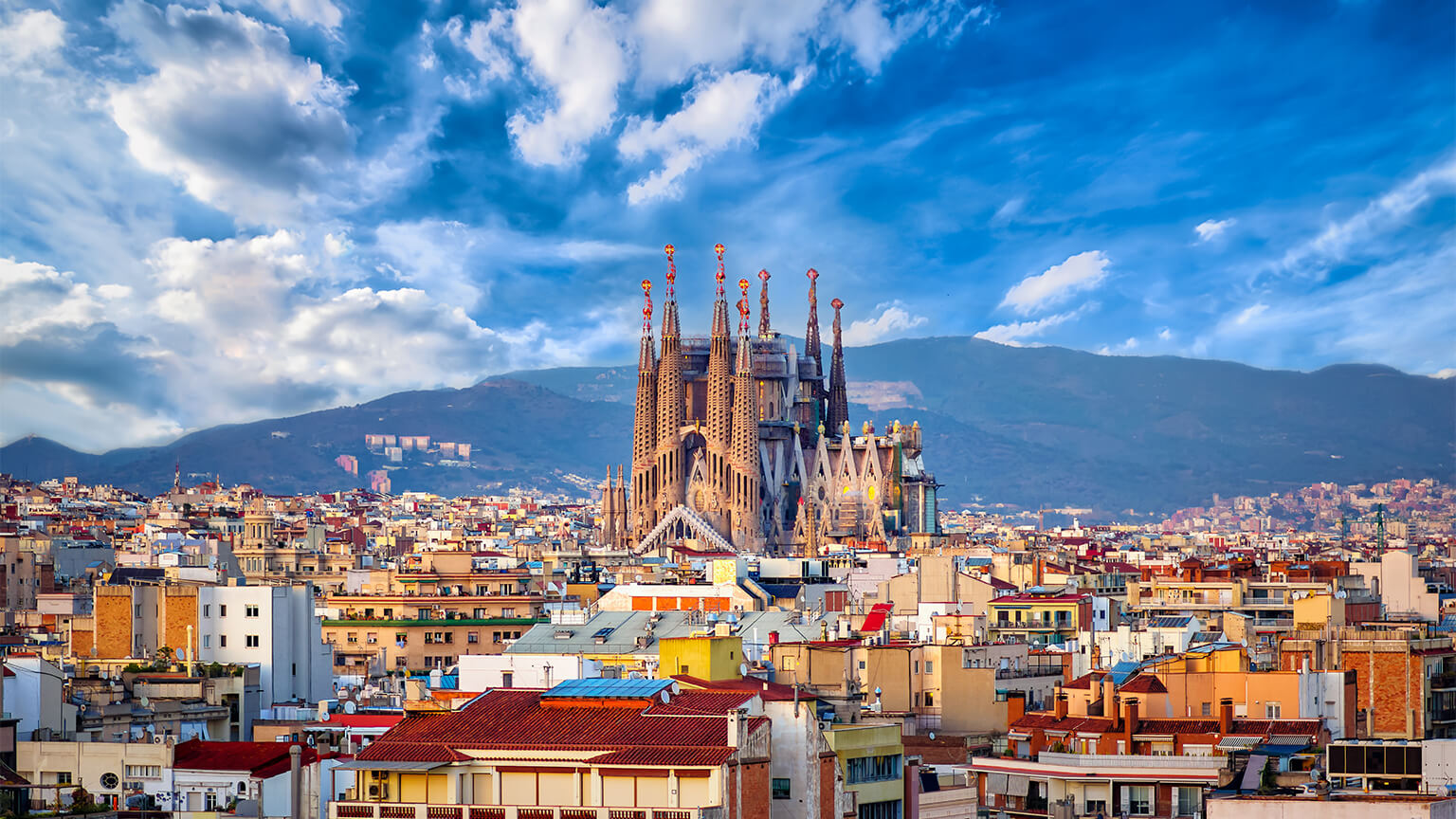 Aerial view of Barcelona skyline, Sagrada Familia rising above the buildings.