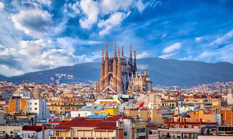 Aerial view of Barcelona skyline, Sagrada Familia rising above the buildings.