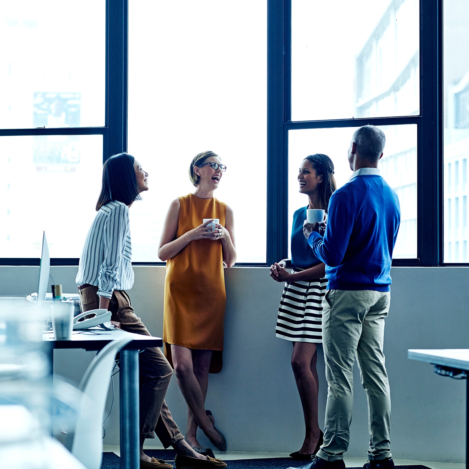 Four employees having a casual chat in office
