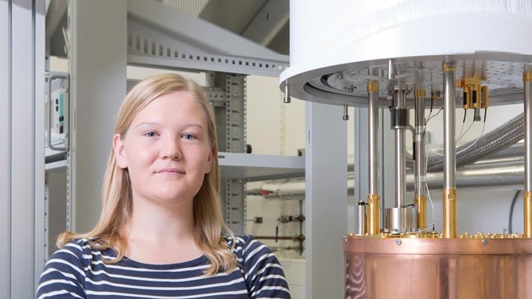 Portrait of a female physicist next to a dilution - stock photo