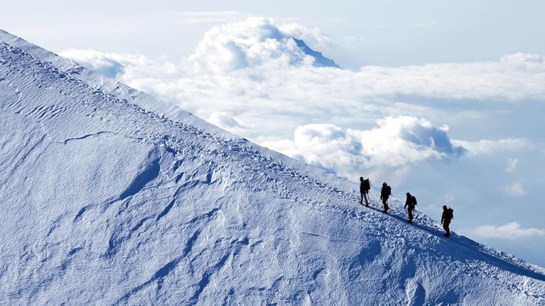 Climbers ascending on a snow mountain peak