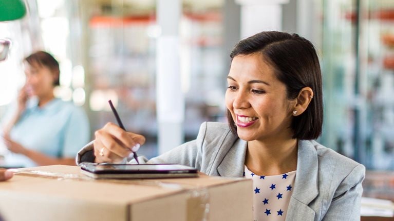 Courier collecting or delivering parcels from small business - stock photo