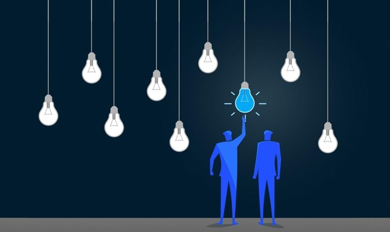 Standing out from the crowd. Two figures point to one red lightbulb in a series of hanging white lightbulbs. - stock illustration