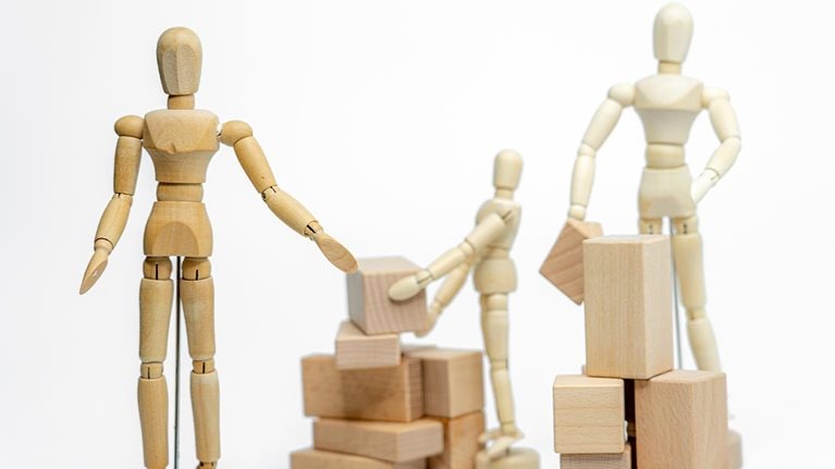 Wooden doll with wooden toy block isolated on white background. business or creative concept - stock photo