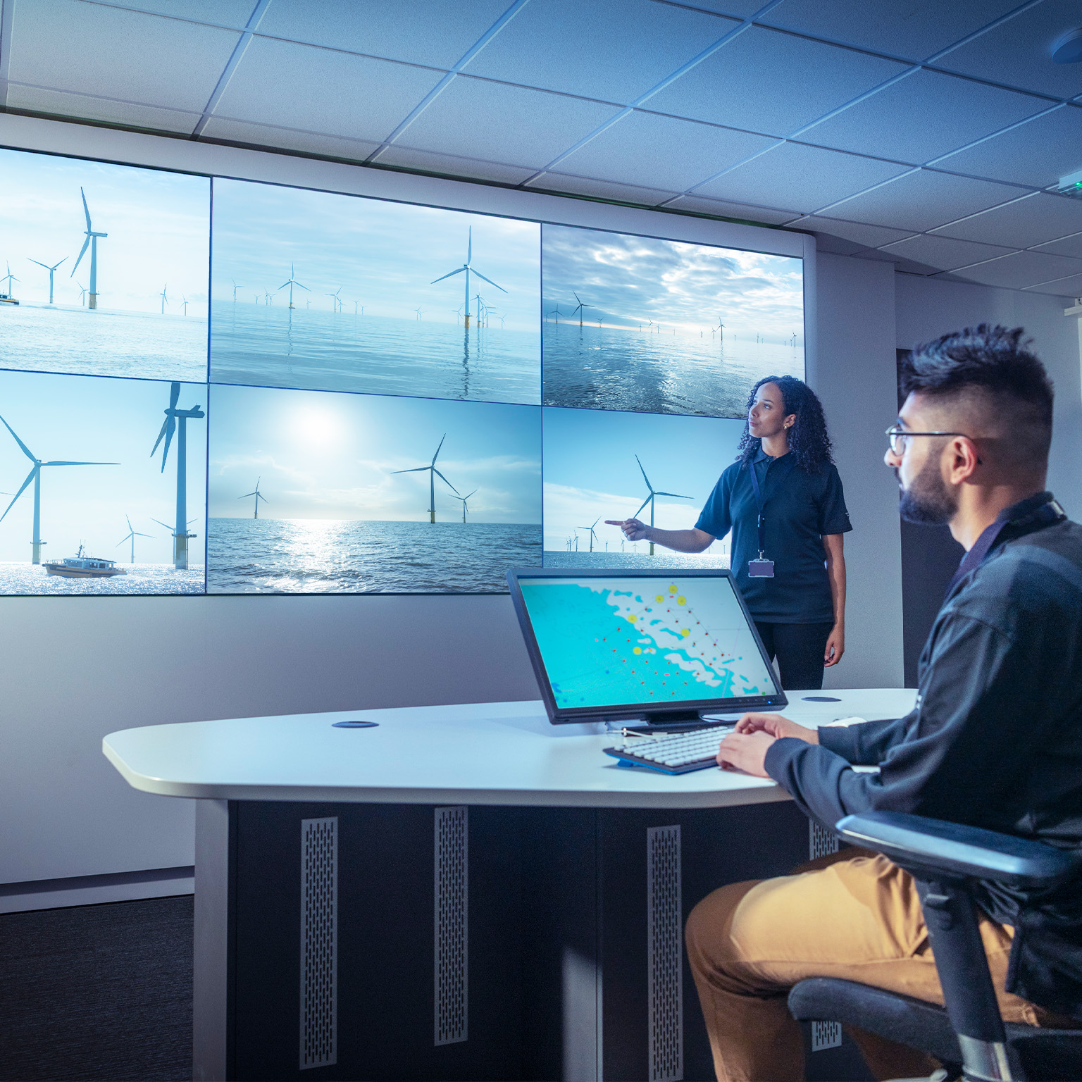 UK, York, Male and female operators in offshore wind farm control room - stock photo