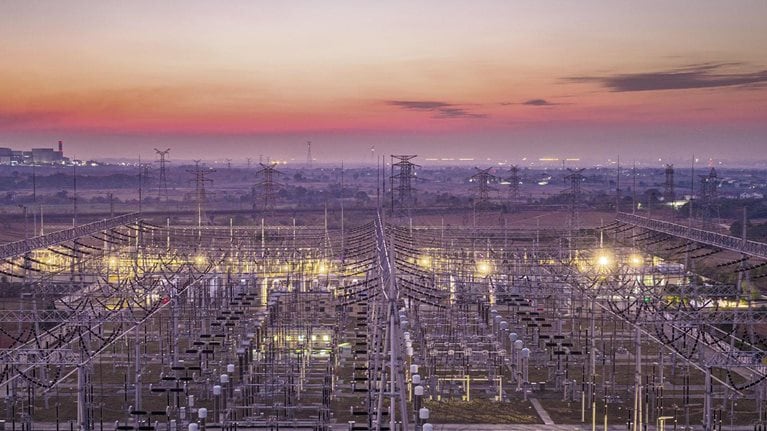Big city, transmission towers at sunset