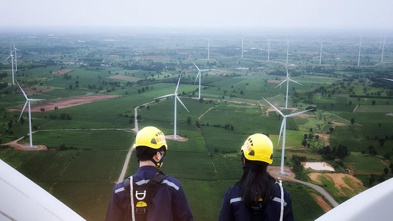photo man and woman standing on top of wind turbine